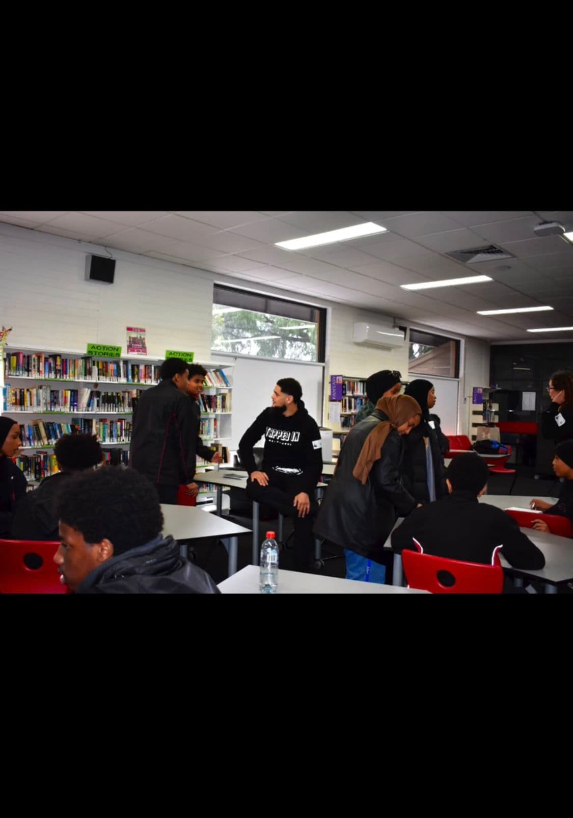 Zayd engaging students in a school library